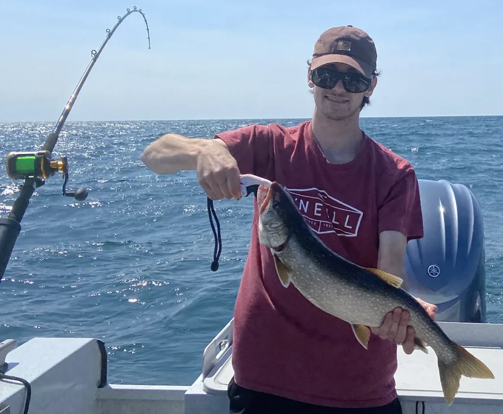 Angler holding Lake Ontario lake trout on private charter