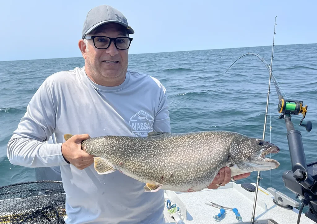 Captain Dave Dunn with a large lake trout during a Lake Ontario fishing charter.
