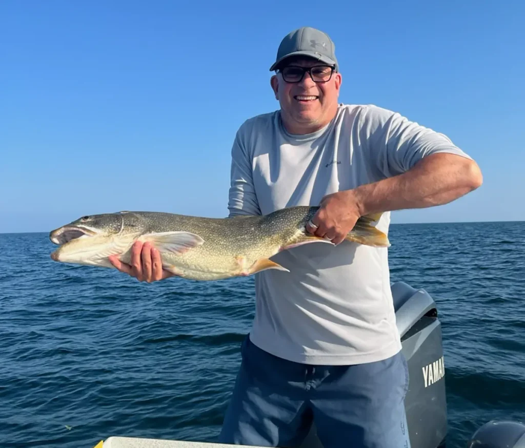 Captain holding tournament-winning Lake Ontario lake trout for Lucky Spoon Charters